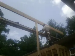 Carpenter setting a ridge beam over a new addition frame — Ice Dam Removal by Roofing Brothers in Marlin