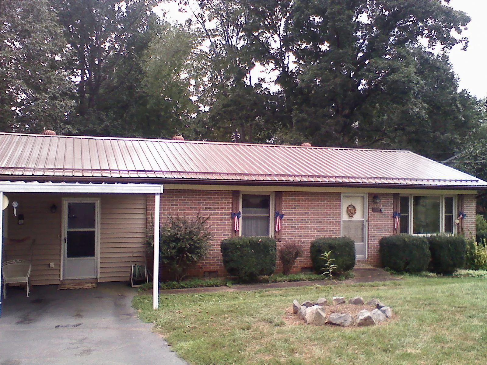 Bronze metal roof and carport on a brick ranch home — Roof Repair work by our crew in Marlin