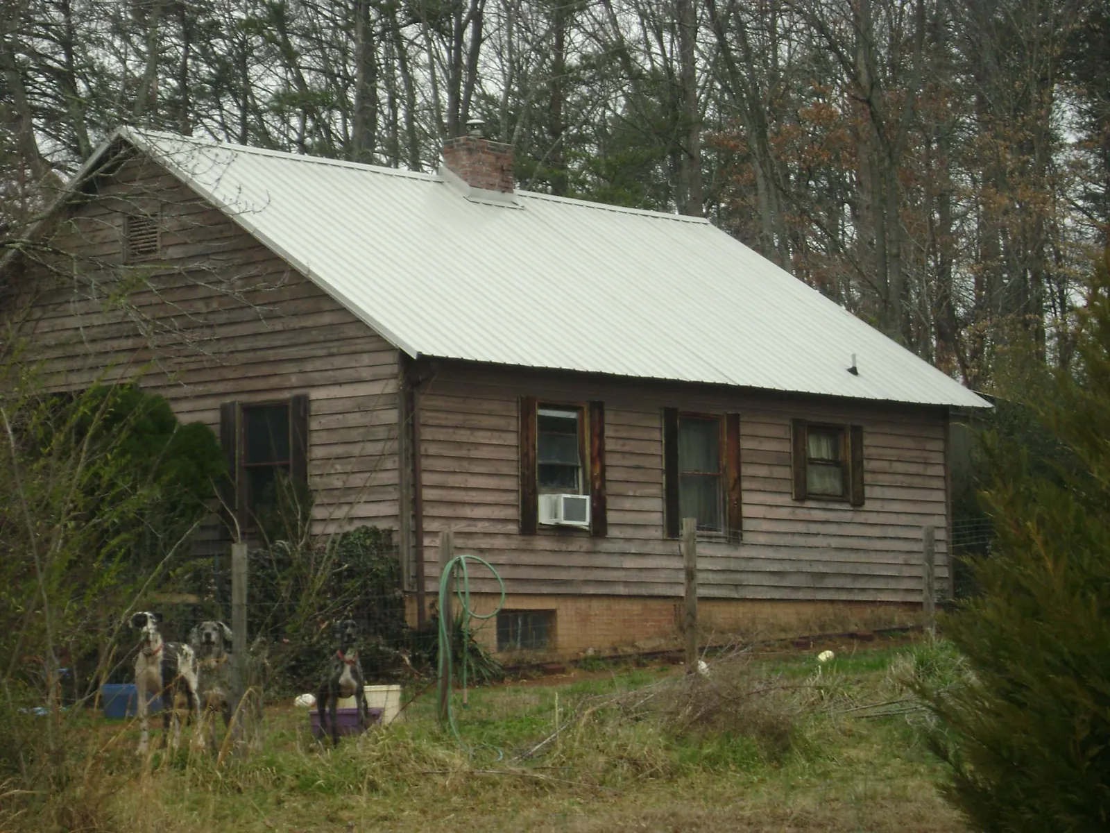White metal roof on an old wood sided farmhouse, from a Metal Roof Installation job in Marlin